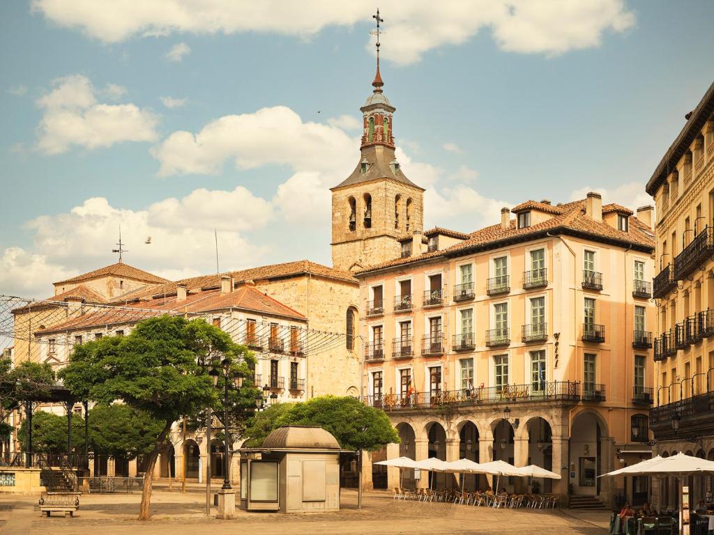 a large building with a tower and a church at Hotel Infanta Isabel by Recordis Hotels in Segovia