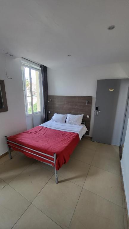 a bedroom with a bed with a red blanket at Anora in Marseille