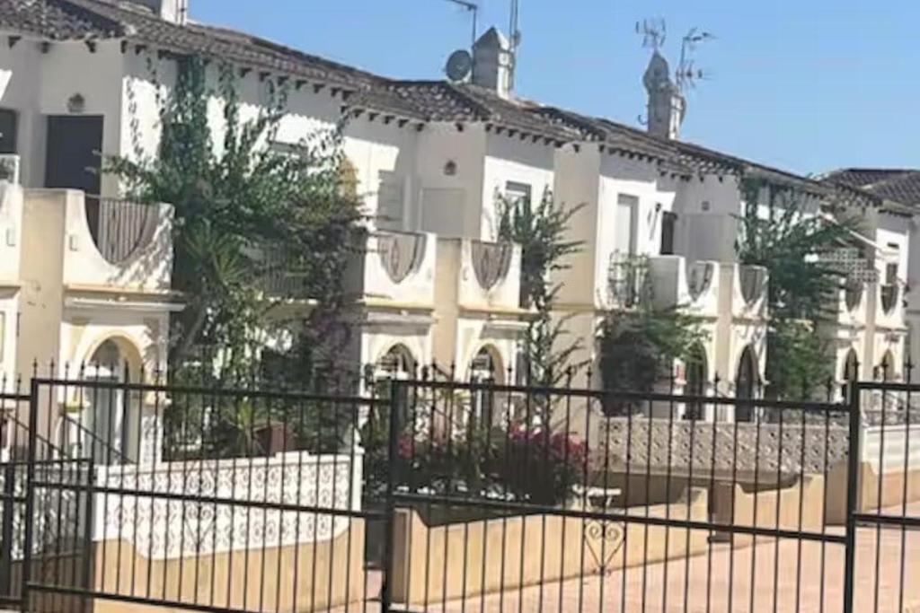 a building with a fence in front of it at 1-Bed Apt 10 mins to Beach Choose from 4 Pools in San Miguel de Salinas