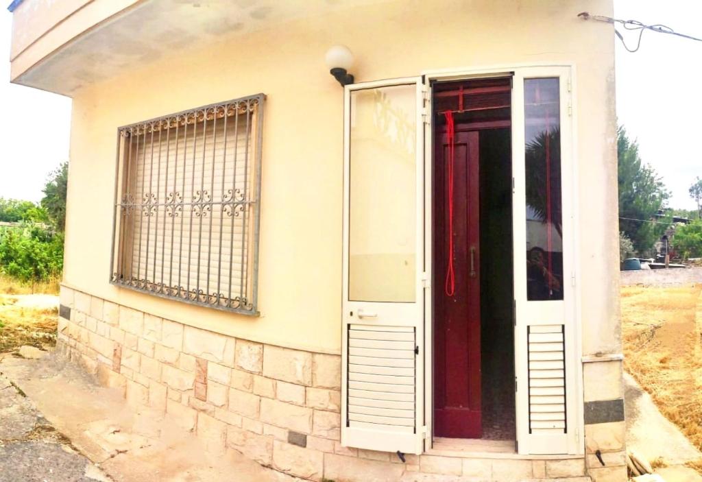 a red door on the side of a house at La casa di Anna Maria in Nardò