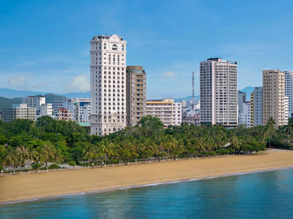 ニャチャンにあるMercure Nha Trang Beachの高層建築物が立ち並ぶ街の前のビーチ
