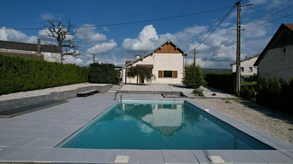 a swimming pool in front of a house at maison en campagne in Vernois-lès-Belvoir