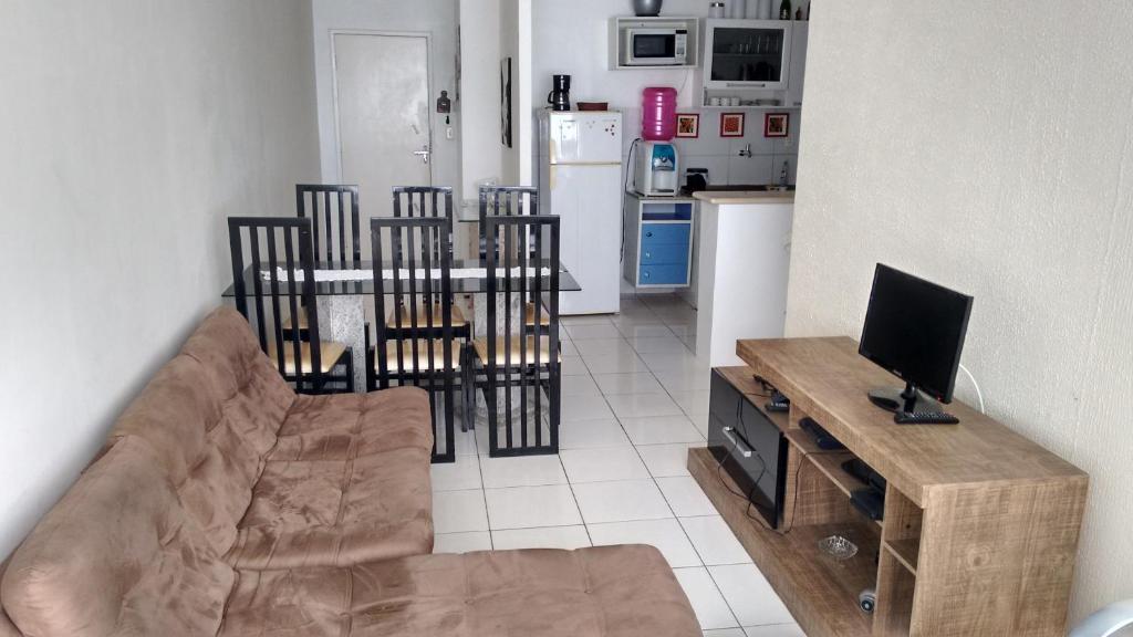 a living room with a couch and a table with a television at Apartamento Bonavides in Fortaleza