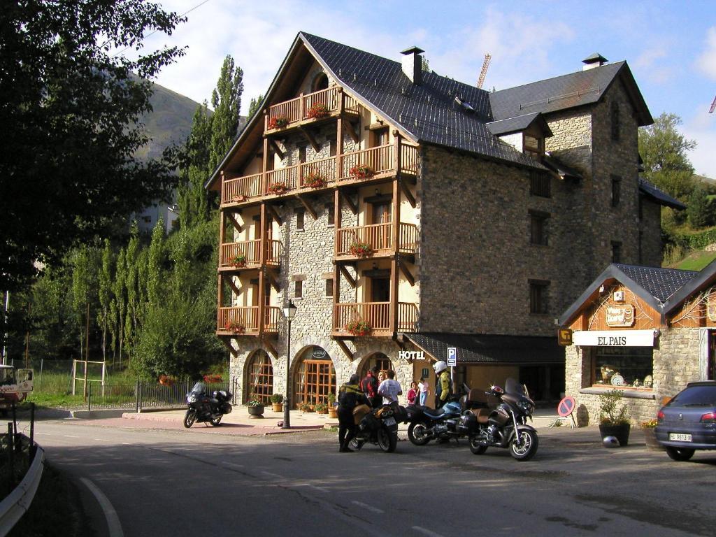 um grupo de pessoas andando de moto em frente a um edifício em Hotel Bocalé em Sallent de Gállego