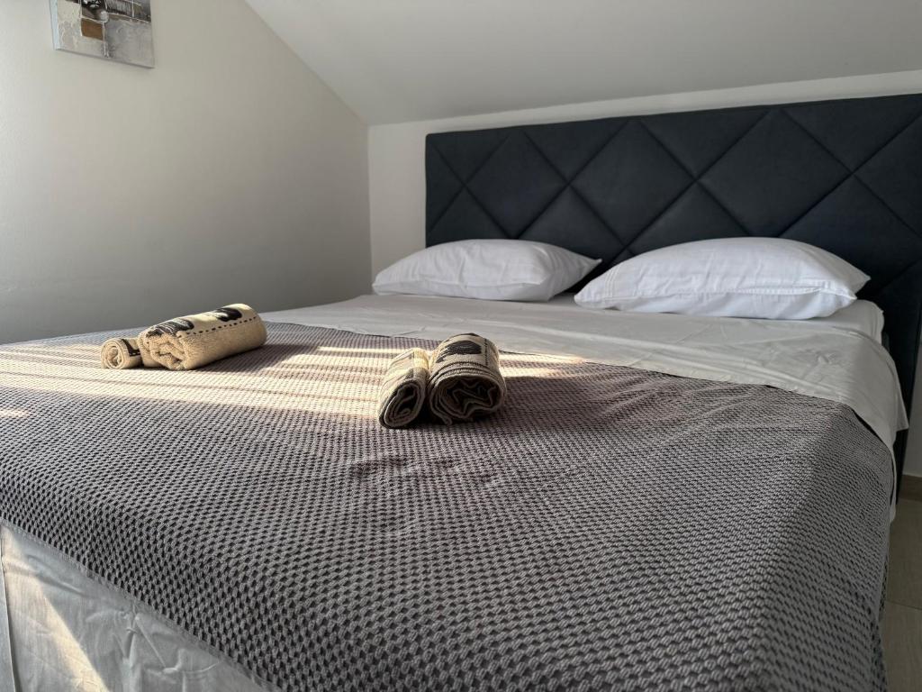 a bedroom with a bed with shoes on it at Golden Wave Apartment in Vir