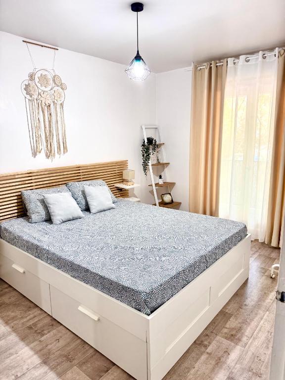 une chambre avec un grand lit dans une pièce dans l'établissement Le Havre de paix Montpelliérain - terrasse et parking privé, à Montpellier