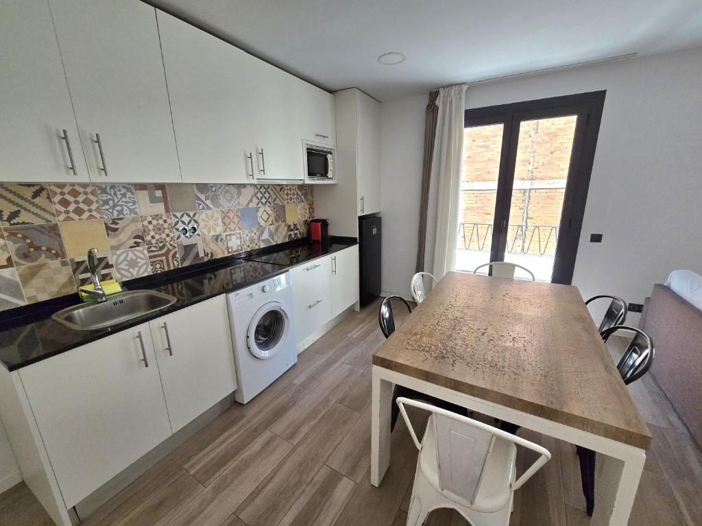 Una cocina con fregadero y una mesa con sillas. en SM Apartments Station, en Lleida