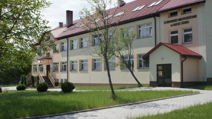 a large building with a building with at Szkolne Schronisko Młodzieżowe w Hucie Starej in Huta Stara