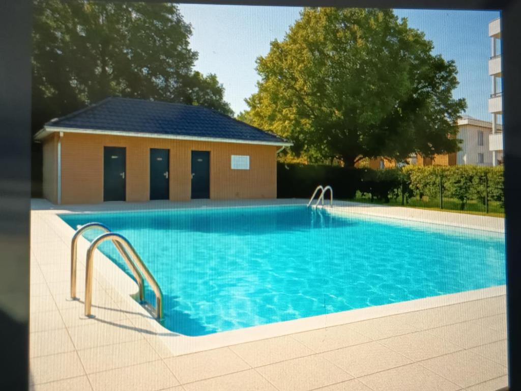 einem Pool mit blauem Wasser vor einem Gebäude in der Unterkunft Appartement avec piscine in Saint-André