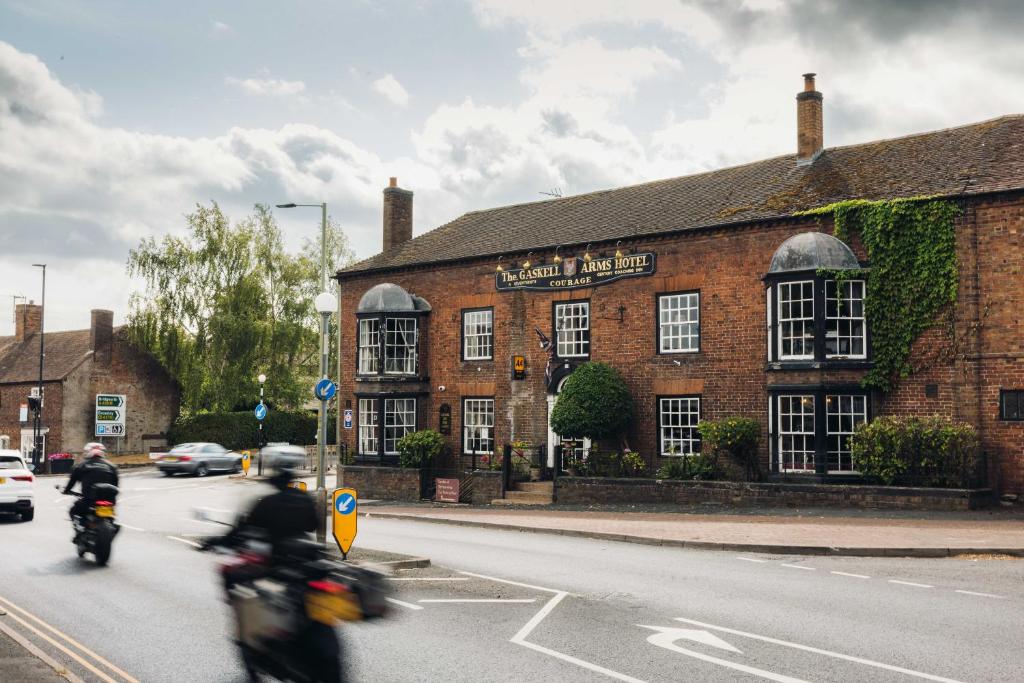 two people riding motorcycles in front of a brick building at Gaskell Arms in Much Wenlock