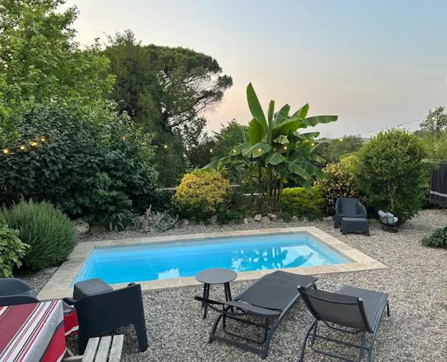 a small swimming pool with chairs and a table and a tablektop at Gite d'étape Chambres D'Hôtes Chez Nous Chez Nous in Miradoux