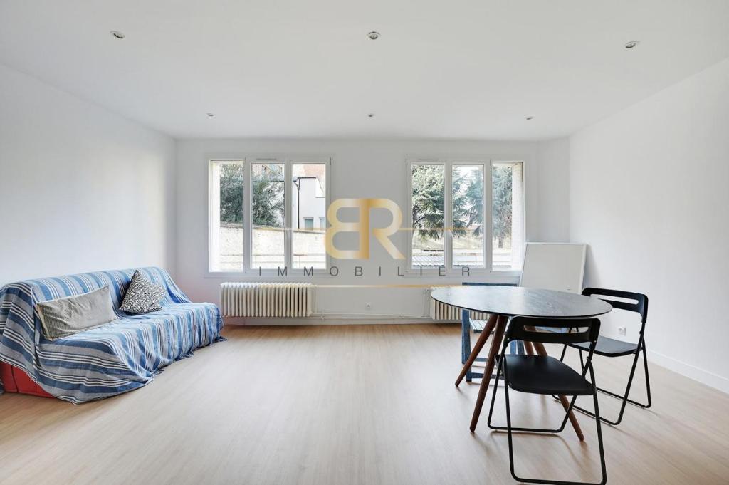 un salon blanc avec une table et un canapé dans l'établissement Renew Spacious & Quiet Apartment, à Paris