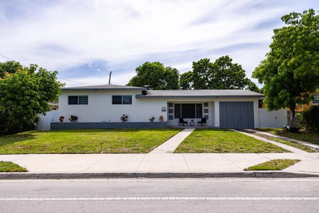 a white house with a driveway at Stylish 3BR Home - BBQ & Near Top Attractions in Miami Gardens