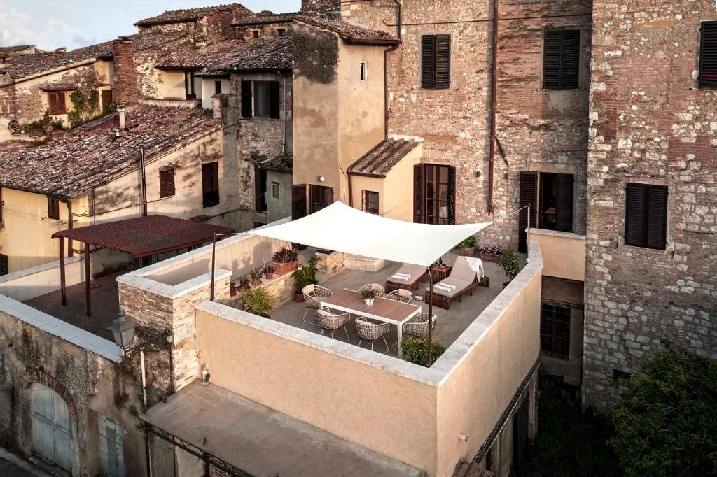 an outdoor patio with a white umbrella on a building at La Casa del Poeta in Colle Val D'Elsa
