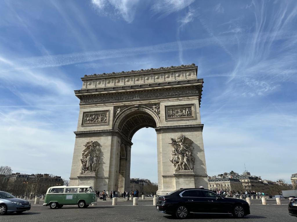 une arche avec des voitures garées devant dans l'établissement Little LV2 Au cœur de l'Avenue des Champs-Elysées Arc de Triomphe, à Paris