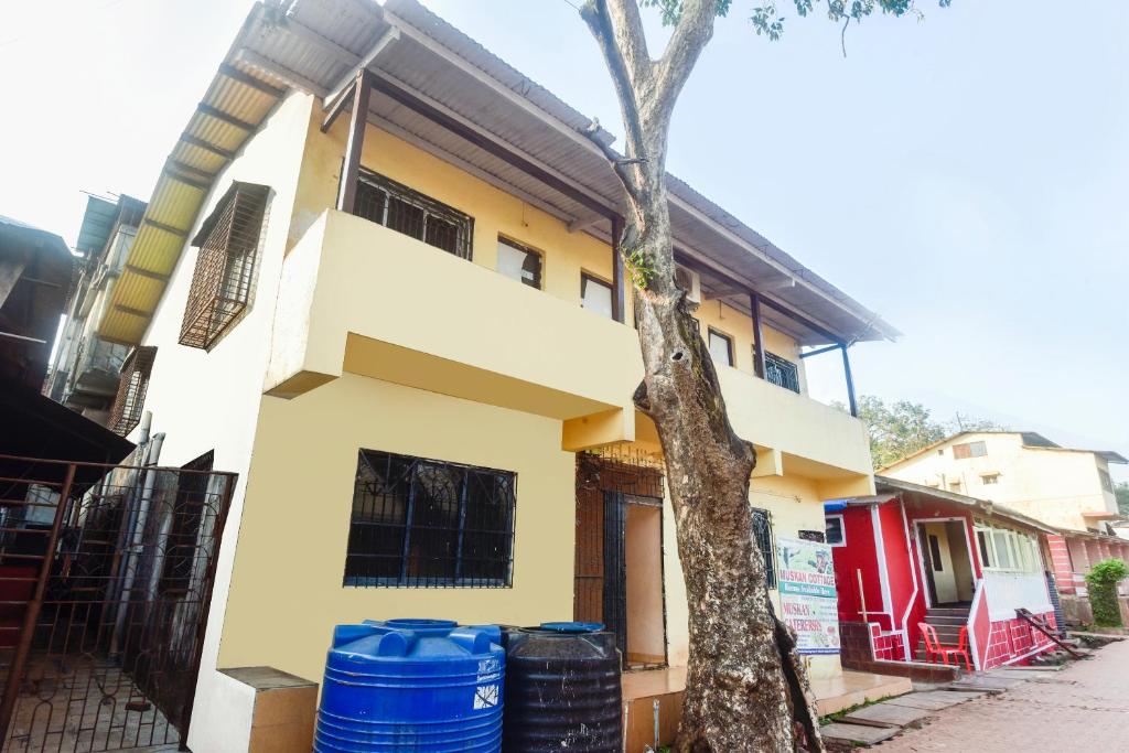 a house with blue barrels in front of it at Hotel O Muskaan Cottage in Matheran