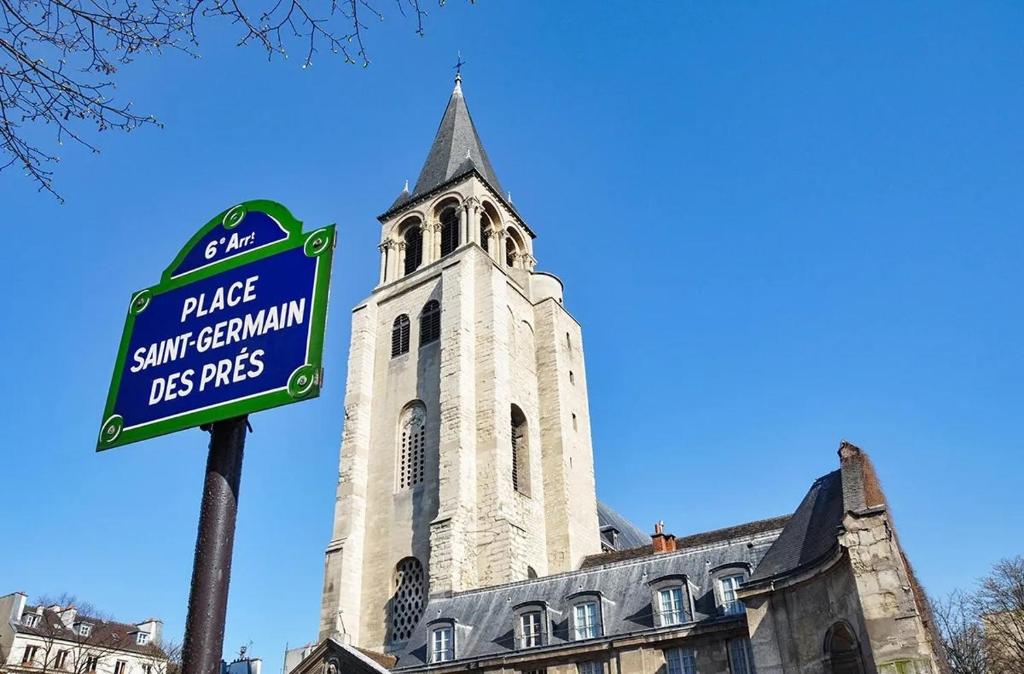 un panneau devant un bâtiment avec une tour dans l'établissement Appartement élégant au cœur de Saint-Germain-des-Prés, à Paris