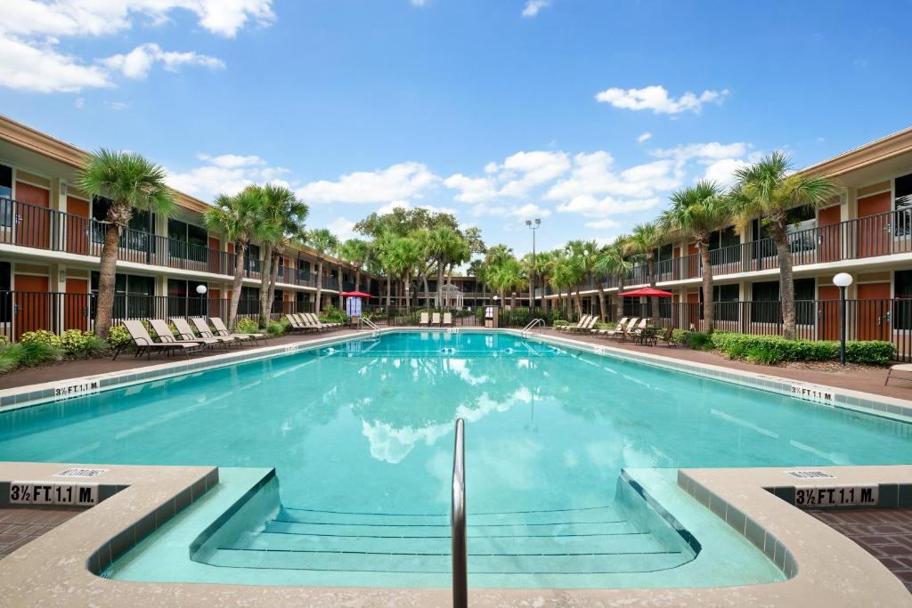 a swimming pool in the courtyard of a apartment building at Ramada by Wyndham Kissimmee Gateway - Free Theme Park Shuttle in Orlando