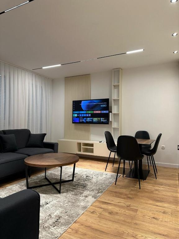 a living room with a couch and a table and a tv at Pristina Luxury Apartments 45 in Pristina
