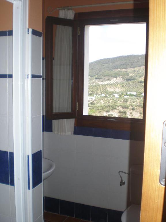 łazienka z toaletą, oknem i umywalką w obiekcie Apartamentos Rurales El Cañuelo de Carcabuey w mieście Carcabuey