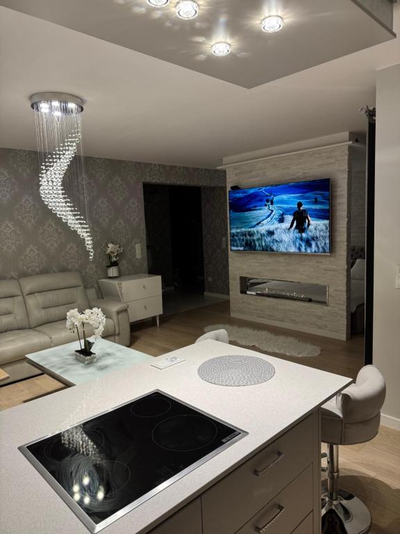 a kitchen and living room with a tv on the wall at AKOYA APARTMENT Cristal Bianco in Koszalin