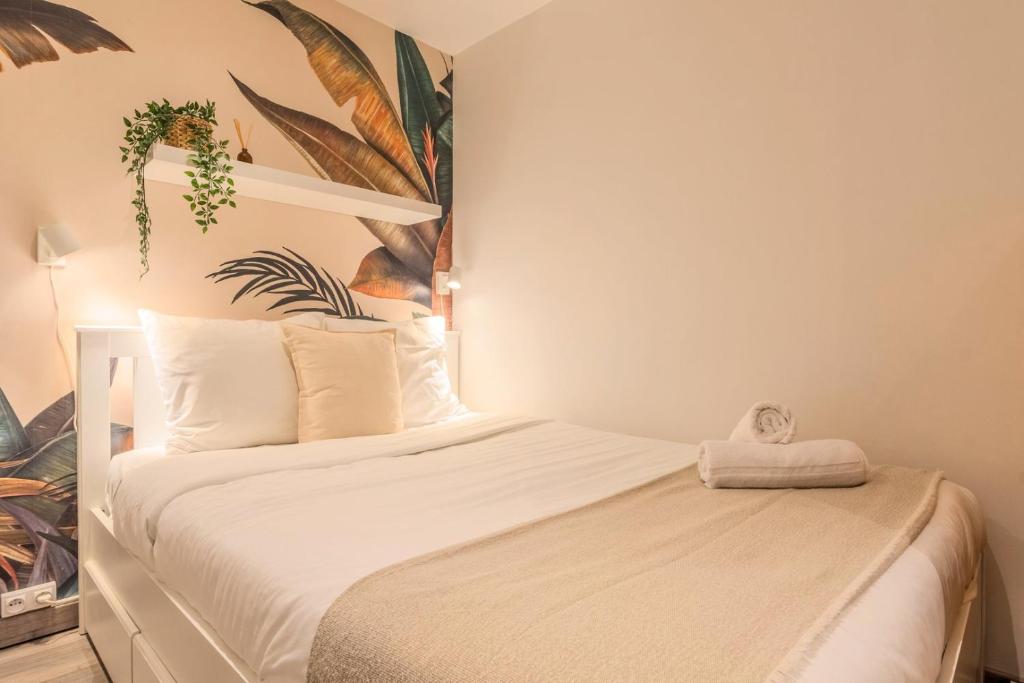 - une chambre avec un lit et une plante sur le mur dans l'établissement Lille Grand-place : Functional and quiet studio !, à Lille