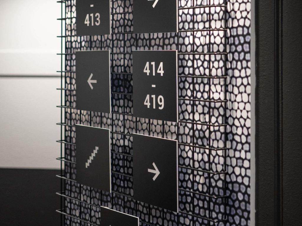 un mur avec des panneaux noirs et blancs dessus dans l'établissement ibis Clermont Ferrand Montferrand, à Clermont-Ferrand