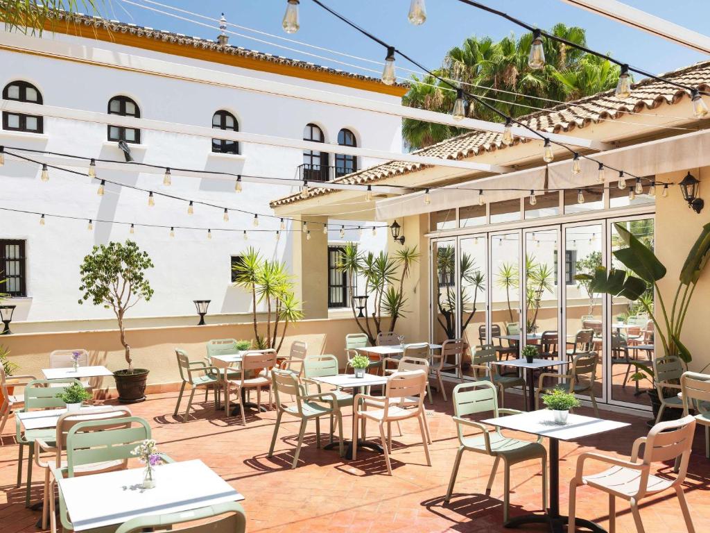 an outdoor patio of a restaurant with tables and chairs at Ibis Sevilla in Seville
