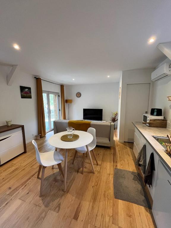 a kitchen and a living room with a table and chairs at Hébergement GÎTE Domaine de Pinsol in Campet-et-Lamolère