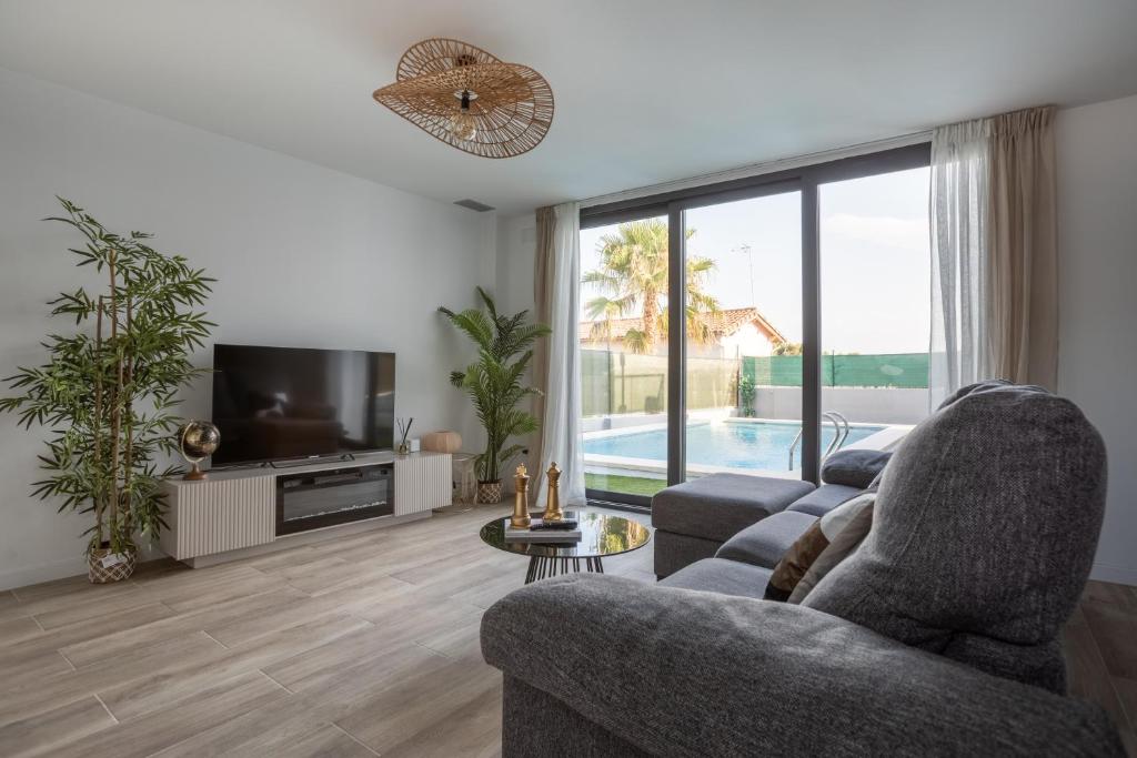 Casa Blanca - Villa con piscina في شيفا: غرفة معيشة مع أريكة وتلفزيون وحامل تلفزيون
