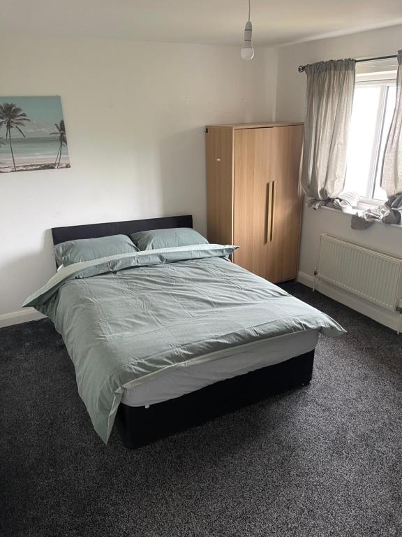 a bedroom with a large bed and a window at ComfortVilla in Hornchurch