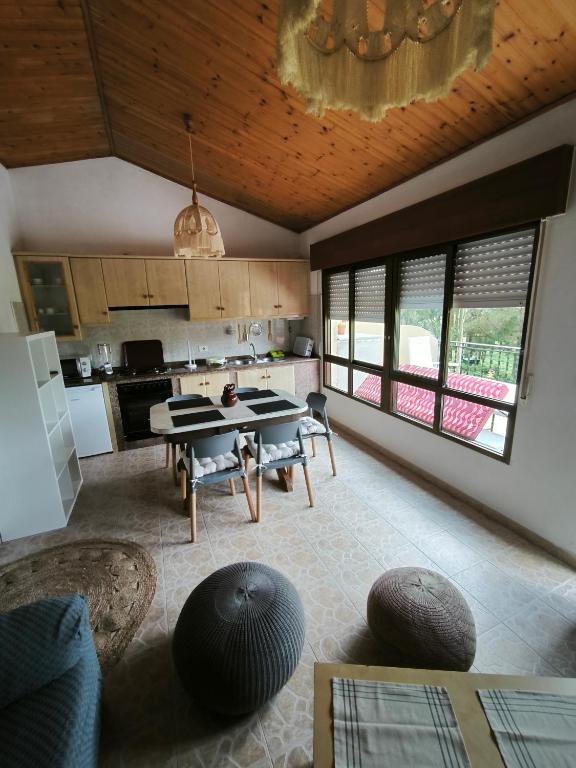 a kitchen with a table and chairs in a room at La terraza de Isabel in O Barqueiro