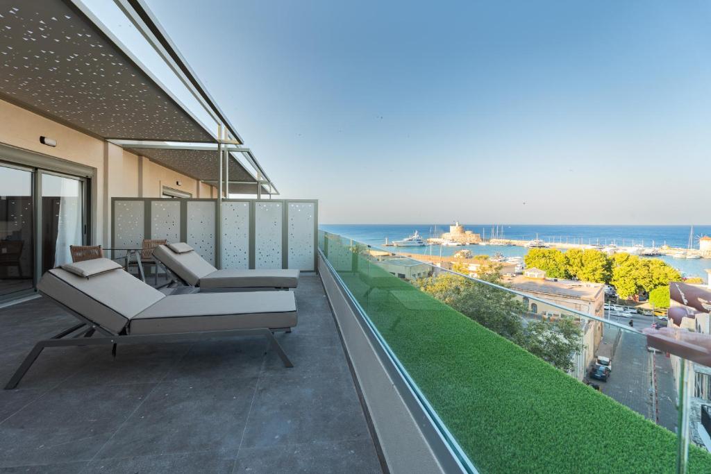 a balcony with chairs and a view of the ocean at Philia Center Suites in Rhodes Town