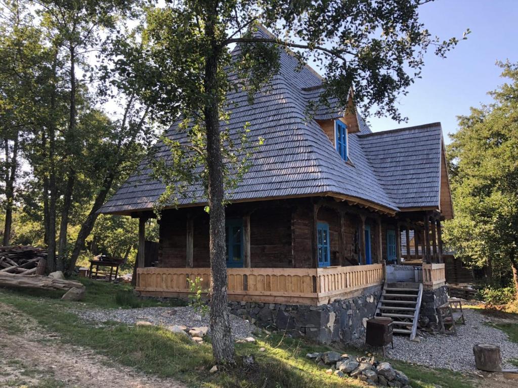 a log cabin with a gambrel roof at Poiana Creasta Cocoșului-Casa Floare De Nu Mă Uita in Breb