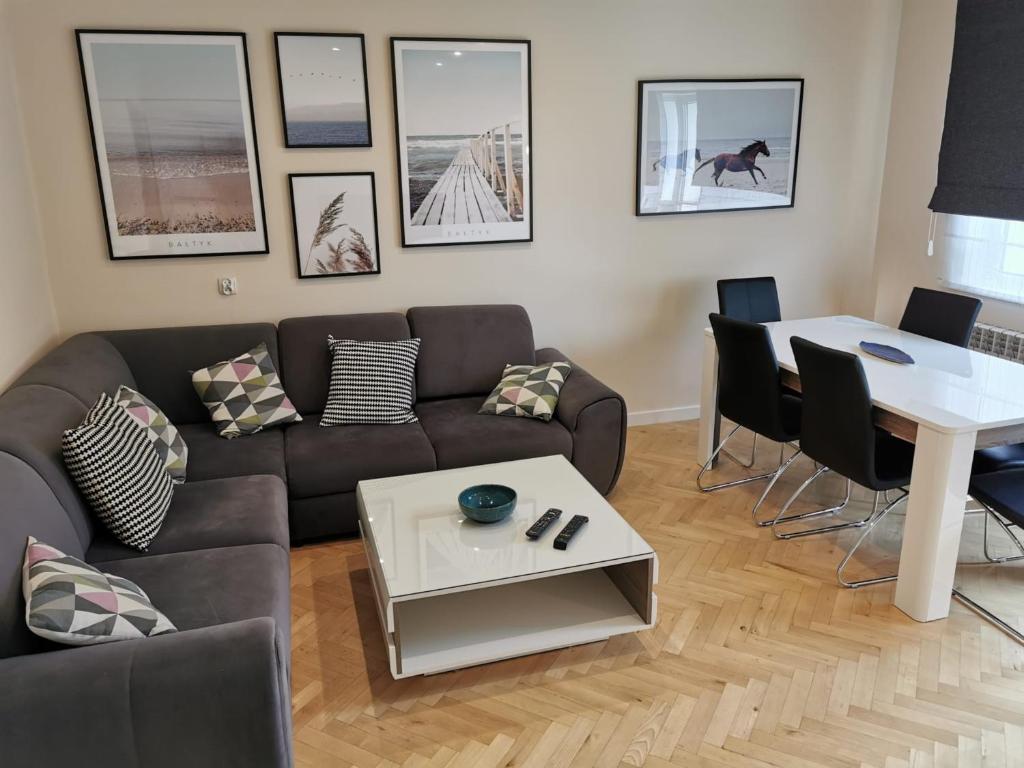 a living room with a couch and a table at Horizon Lu Apartment by the Sea in Sopot