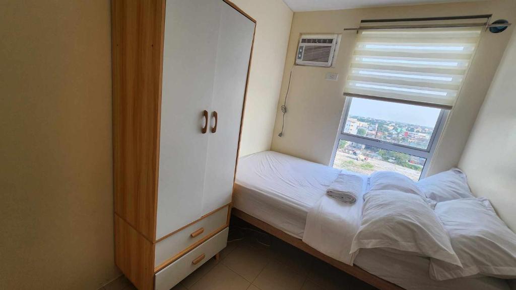 En eller flere senge i et værelse på URBAN DECA Homes SM EAST Pasig