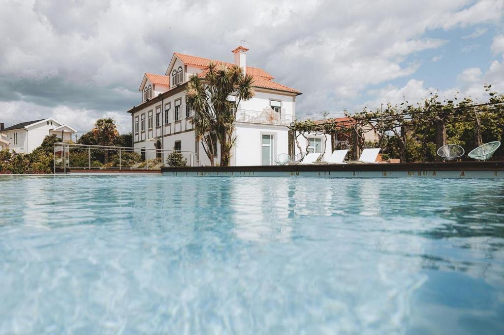 a large swimming pool in front of a house at Porta do Jardim in São Pedro do Sul