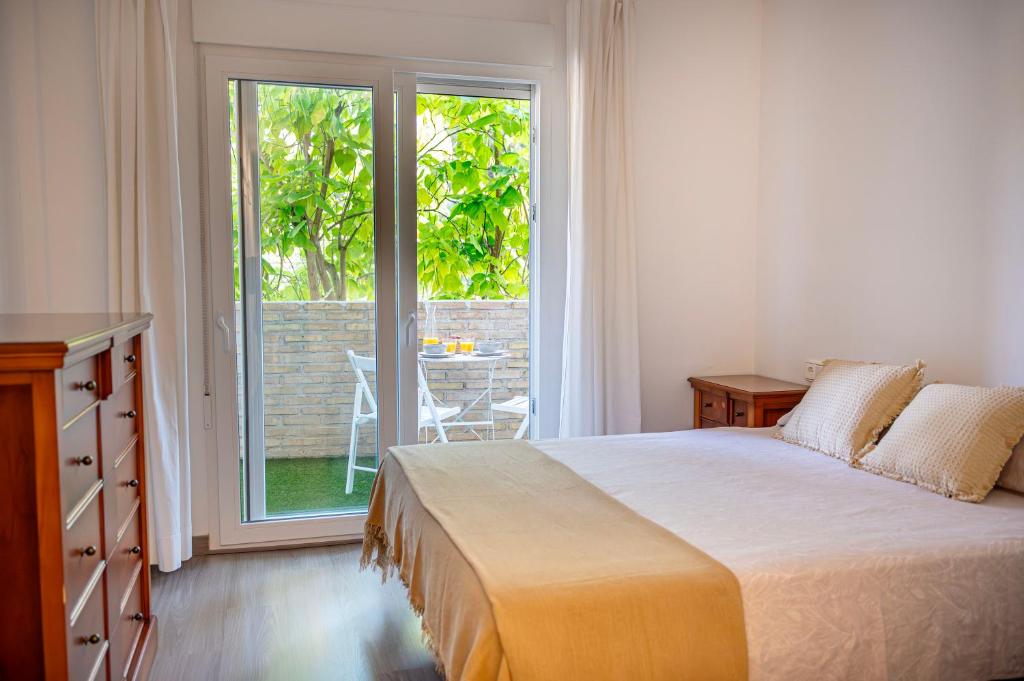 een slaapkamer met een bed en een glazen schuifdeur bij Estancia Mar y Montaña in Jávea
