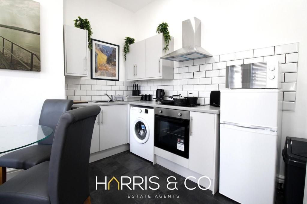 a white kitchen with a washer and dryer in it at Roundtree & Berry - Fleetwood in Fleetwood