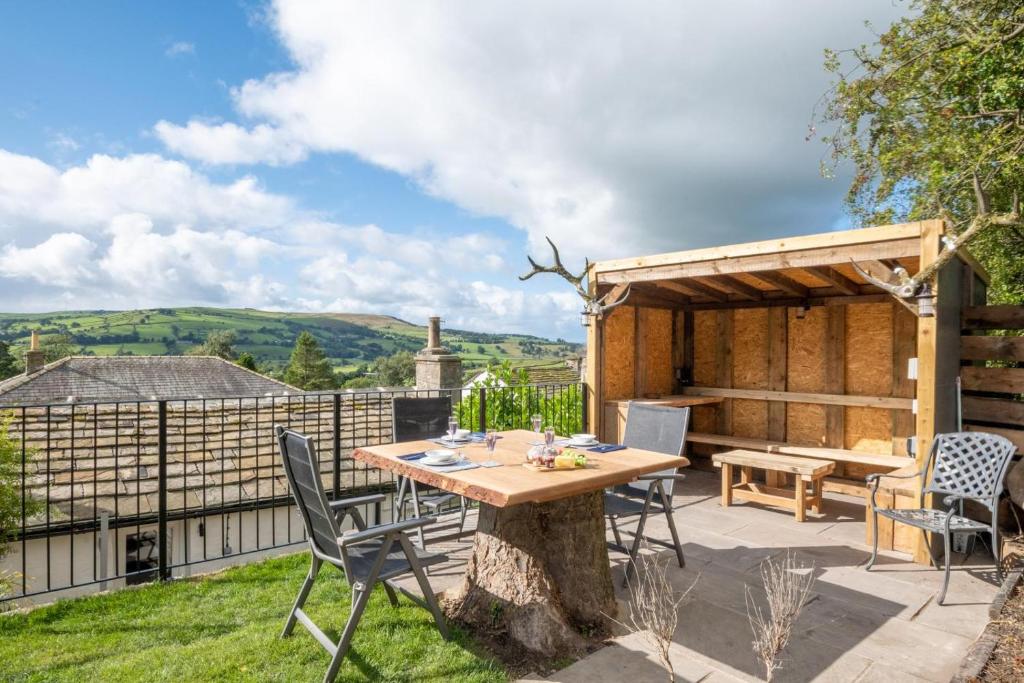 a patio with a wooden table and chairs and a fence at 3 Ivy Terrace in Bradley