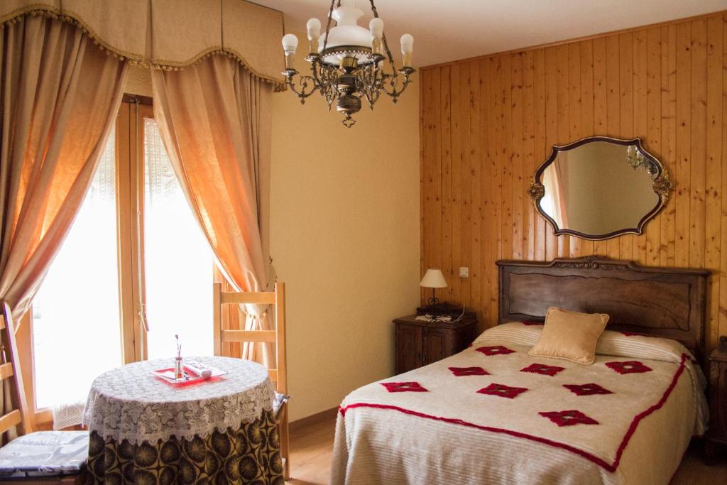 a bedroom with a bed with a table and a mirror at Hospederia del Comendador in Ocaña