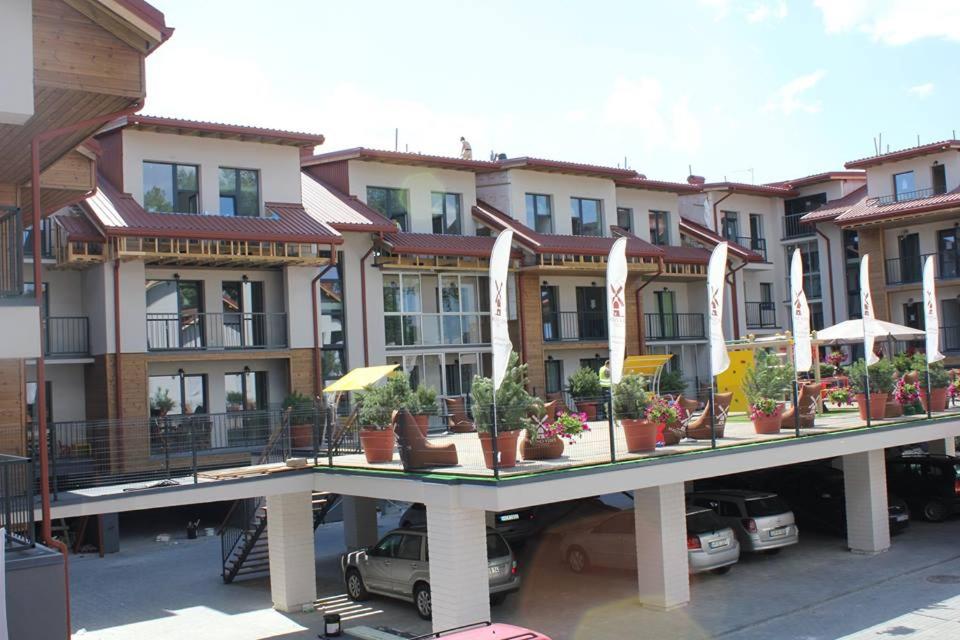 a row of buildings with potted plants on a bridge at Bears Apartments in Palanga