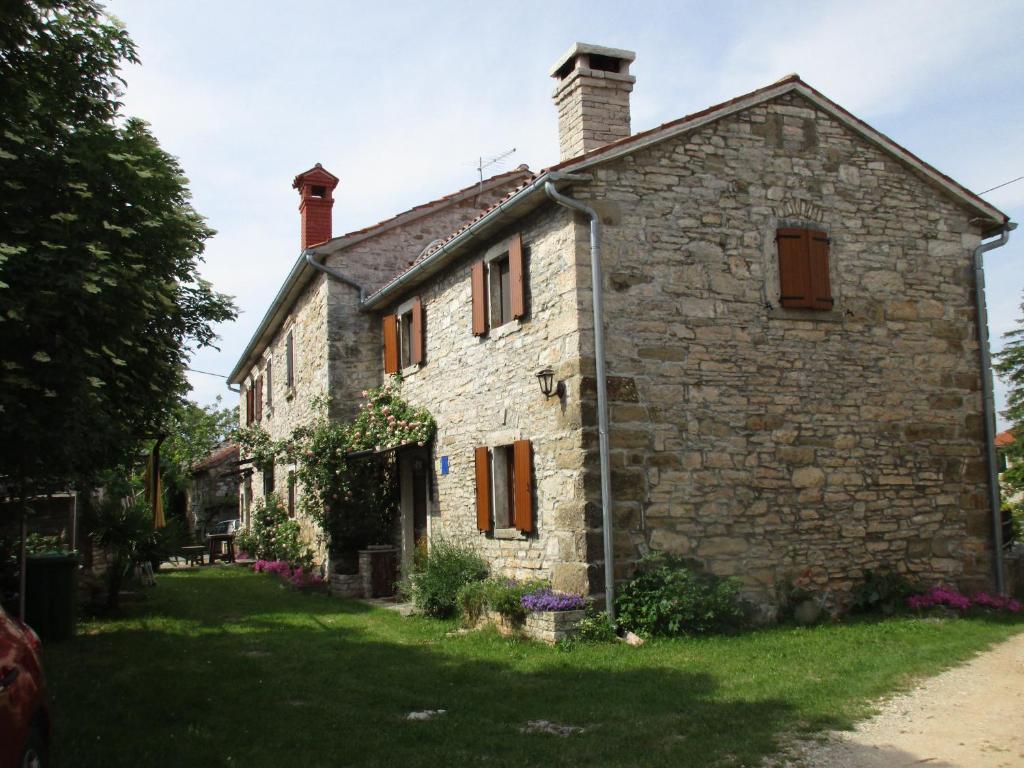 una antigua casa de piedra en el pueblo de la persona en Agroturizam Nežić, en Oprtalj