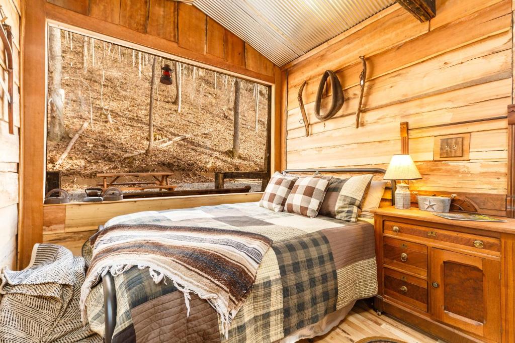 a bedroom with a bed and a window in a cabin at Ohio Starlight Glamping Cabins - A Peaceful Woodland Retreat 