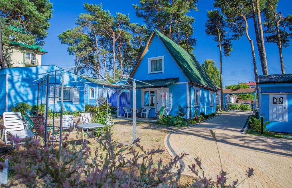 a blue house with a green roof at Proxial - domki letniskowe in Międzywodzie
