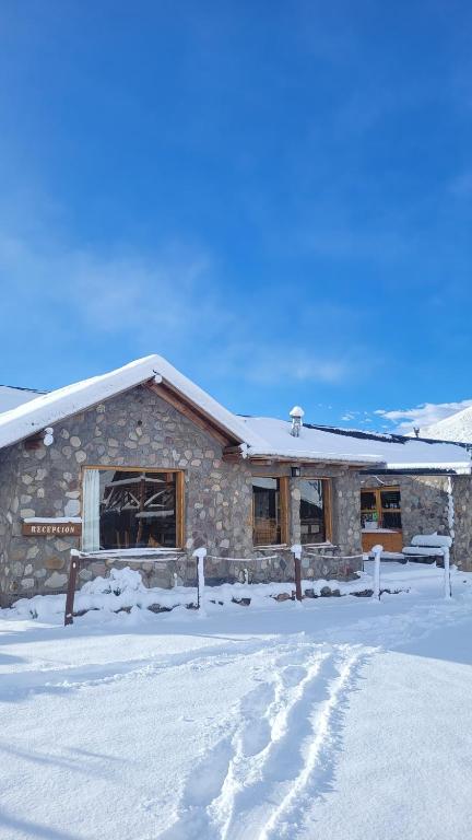 a building with snow on the ground in front of it at Los Molles Complejo Turistico in Los Molles