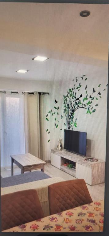 Hotel Apartamento Jardín de Ayora, a living room with a tv on a wall with a plant mural at Apartamento Jardín de Ayora in Valencia