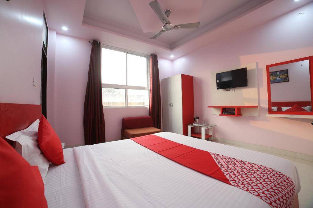 a bedroom with a bed and a window and a tv at Hotel O Jai Ambay International in Jaipur