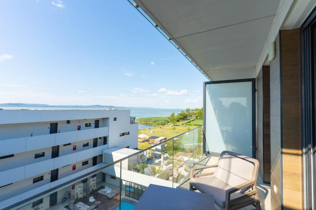 a balcony with a chair and a view of the ocean at Sunset Resort 408 in Fonyód