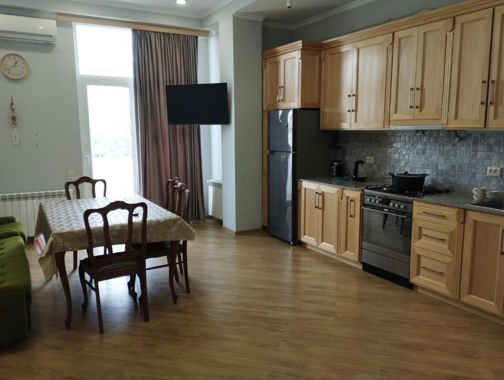 a kitchen with a table and a black refrigerator at Two bedroom apartment Mikheil in Kutaisi